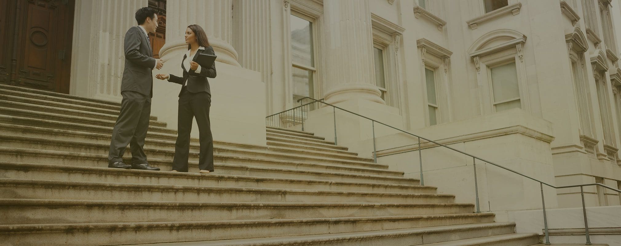 Two lawyers talking in front of a court house